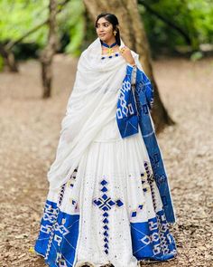 This Habesha Kemis is a true work of art, with its stunning Menen fabric and intricate blue design. The Menen fabric is known for its softness and durability, making this Kemis not only beautiful but also comfortable to wear. The blue design is both striking and delicate, with a pattern that is reminiscent of the intricate designs found in traditional Ethiopian art and textiles. The blue design extends down the front of the Kemis, creating a visually stunning centerpiece that draws the eye and c Ethiopian Art, Ethiopian People, Eritrean Dress, Habesha Dress, Ethiopian Traditional Dress, Ethiopian Dress, Habesha Kemis, Traditional Jewelry, Blue Design