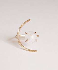 This beautiful white moonstone gemstone features a subtle glow. Set in 14k gold fill, this ring is a perfect for everyday wear or as a statement piece.Featuring a stunning crescent moon shape design.Ring is made in size 6 and is adjustable due to the style of the ring.It can be made larger upon request before purchase.Gemstone is approx. 10mm in diameter.This piece is a very limited edition.Please note: Due to the nature of the moonstones, each of these stones can vary from the original.My QUALI Adjustable Crescent Moonstone Ring, White Moonstone Celestial Ring In Moon Shape, Celestial White Moonstone Ring In Moon Shape, Moonstone Crystal Ring With Moon Phase, Moonstone Open Ring With Moon Phase Detail, Minimalist Moonstone Moon-shaped Ring, Modern Adjustable Moonstone Gemstone Ring, Modern Adjustable Moonstone Ring, Mystical White Moonstone Ring In Moon Shape