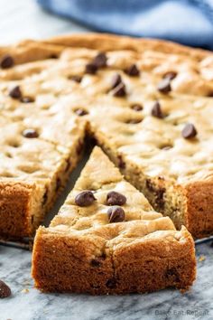 a chocolate chip cookie cake with one slice cut out and ready to be eaten from it