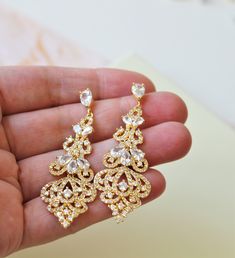 Gold Bridal Earring Crystal Earring Vintage Style Wedding Earring Chandelier  Wedding Jewelry Bridesmaid Earrings   Vintage style zircon  earrings  Colour: yellow gold /clear Measurements: approx 5.8 cm including studs(medium size not very long).  Materials:  rhodium components, zircon crystals . Stud earrings. Great for wedding or other celebration. Same style in rose gold: MORE SAME STYLE: https://www.etsy.com/uk/shop/BridalArtDeco?ref=listing-shop-header-item-count&section_id=23918122 Please Gold Earrings With Intricate Design For Wedding, Gold Bridal Earrings With Intricate Design, Gold Bridal Earrings With Intricate Design For Wedding, Glamorous Sparkling Diamond Earrings For Wedding, Glamorous Sparkling Diamond Wedding Earrings, Glamorous Drop Diamond Earrings For Wedding, Gold Hand-set Bridal Earrings For Wedding, Gold Hand Set Bridal Earrings For Wedding, Silver Diamond Earrings With Intricate Design For Wedding