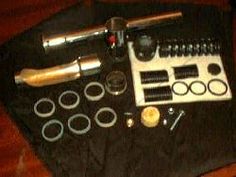 an assortment of tools are laid out on a black cloth with gold trimmings