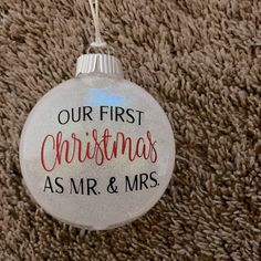 a glass ornament that says our first christmas as mr and mrs