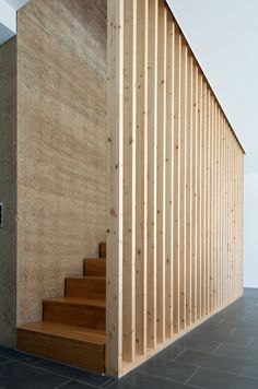 a wooden stair case next to a wall