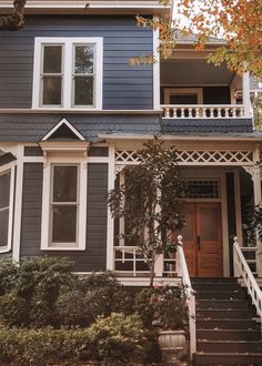 a blue house with white trim on the front door and steps leading up to it