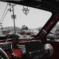 the interior of an old car with mountains in the backgrouund and power lines overhead