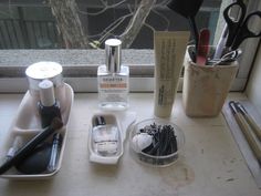 an assortment of beauty products sitting on a window sill