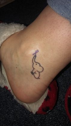 a small elephant tattoo on the foot of a woman's left leg and ankle