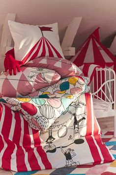 a bed with red and white bedspreads on top of it, next to an ikea sign