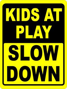 a black and yellow sign that says kids at play slow down