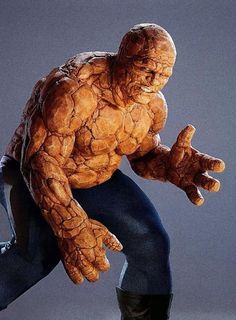 a statue of the thing - man is posed in front of a gray background