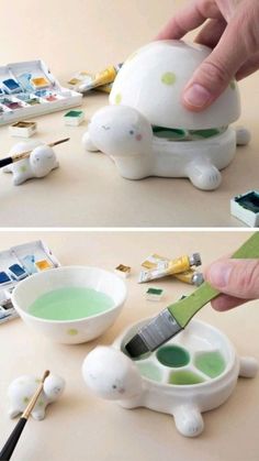 someone is painting a turtle with green paint on it's body and the other hand is holding a brush