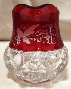 a red glass stopper sitting on top of a white table