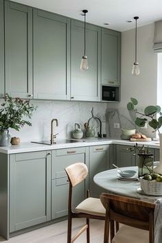 a kitchen filled with lots of green cabinets and counter top space next to a dining room table