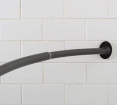 a black pipe is attached to the wall with white tiles in the backround