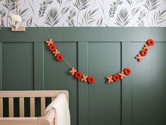 a baby's room with green walls and red decorations on the wall, along with a crib