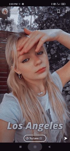 a woman with long blonde hair is looking at the camera and has her hand on her head