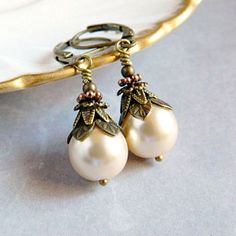 Victorian Pearl Earrings - Ivory Cream Bridal Earrings - Vintage White Pearl Drops - Rustic Boho Wedding .. .. .. These ornate Victorian Pearl Earrings are adorned in layers of graceful vintage style antique gold bead caps, and small round beads. The Czech glass pearls are designed with a rustic boho flair. Personalized your Pearl Earrings with your choice of pearl colors. Select Victorian Cream or White Pearls from the drop down menu. Pearl Earrings always make a thoughtful gift for her. . . . Classic Cream Wedding Jewelry, Elegant Formal Earrings With Vintage Charm, Elegant Vintage Charm Earrings For Wedding, Elegant Vintage Charm Wedding Earrings, Elegant Vintage Charm Earrings For Formal Occasions, Cream Pearl Earrings For Formal Occasions, Cream Pearl Drop Jewelry For Anniversary, Vintage Pearl White Wedding Jewelry, Bronze Vintage Charm Jewelry For Wedding