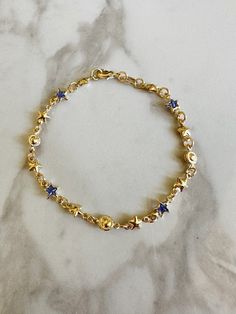 "Perfect worn on its own or layered with our other bracelets. 18k gold filled. Cubic zirconia 7\" length Ready to ship *18k gold filled is a more affordable alternative to solid gold jewelry. Gold filled is a layer of gold bonded onto a base metal with heat and pressure that contains 100+ times more gold than gold plated jewelry.  *It is very durable and tarnish resistant.  *With proper care, gold filled jewelry can last several years. Avoid contact with harsh chemicals, perfumes, water, etc.  *Gold filled jewelry can be worn by people with sensitive skin because it is hypoallergenic, lead free and nickel free." Gold Star-shaped Celestial Bracelets, Gold Star-shaped Celestial Bracelet, Celestial Gold Star Bracelets, Blue And Gold Bracelets, How To Layer Bracelets, Gold And Blue Aesthetic, Gold And Blue Jewelry, Tiffany Bracelet Stack, Dainty Bracelet Stack