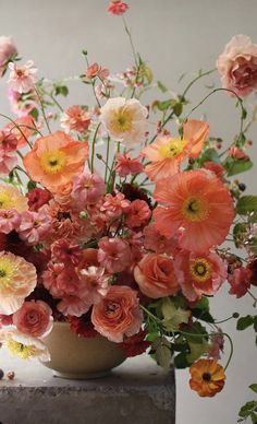 a vase filled with lots of flowers on top of a table