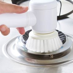 a person using a brush to clean a sink drain