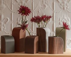 four vases with flowers in them on a table