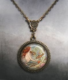 "The Little Mermaid Art Nouveau necklace (Listing 103) Edmund Dulac's beautiful illustration for Hans Christian Andersen's \"The Little Mermaid\" has been set into an Art Nouveau styled necklace. The chain closes with a toggle clasp and lobster clasps are also available upon request at no extra charge. We have 5 lengths of chain to choose from at checkout (18\", 21\", 24\", 27\" and 30\") and if you need a custom length, please let us know. The pendant measures 1-3/16\" across (30mm) and the art The Little Mermaid Necklace, Antique Mermaid, Mermaid Art Nouveau, Little Mermaid Necklace, Moon Goddess Jewelry, Moon Goddess Necklace, Fairy Tale Jewelry, Edmund Dulac, Art Nouveau Necklaces