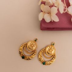 Description: Step into minimal sophistication with our exquisite antique gold-plated Chandbali earrings. Delicately adorned green kempu stones accentuating the Lakshmi temple coin, it exudes timeless allure and sophistication in every detail. Perfect for enhancing any ensemble, these earrings effortlessly harmonize with other antique jewelry for a refined and coordinated look. Details & Specification: Materials used: Brass Alloy with Antique Gold Plating Weight - 10.2 gm Length - 3.5 cm Make it Lakshmi Coin Earrings Gold, Temple Jewelry Earrings, Green Stone Studs Gold, Lakshmi Earrings Gold, Kasu Earrings Gold, Chandbali Earrings Gold Antiques, Gold Earrings Designs Indian, Green Stone Earrings Gold, Gold Earrings Designs For Daily Use