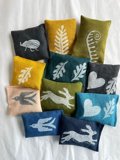 six decorative pillows with different designs on them, all in various colors and sizes are shown