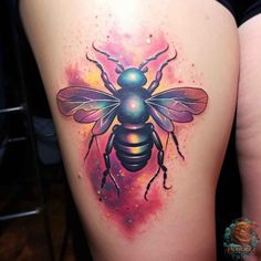 a bee tattoo on the back of a woman's thigh, with space in the background