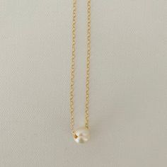 Just A Pearl! This simple yet elegant necklace is part of my Just A Pearl collection. One single pearl dangles from a delicate gold necklace. It measures 16 inches and length and can be adjusted to 15 inches for choker length. Minimalist White Chain Necklace With Pearl Pendant, Classic Pearl White Chain Necklace With Pearl Pendant, Classic White Pearl Charm Necklaces, Minimalist Everyday Charm Necklace With Pearl Chain, Elegant Everyday Charm Necklace With Simple Design, Classic Gold Charm Necklace With Pearl Drop, Classic Pearl Pendant Chain Necklace, Dainty Charm Necklace With Pearl Chain And Round Pendant, Classic Gold Pearl Chain Charm Necklaces