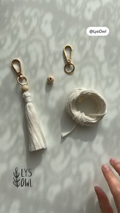 two white tassels are being held by someone's hand