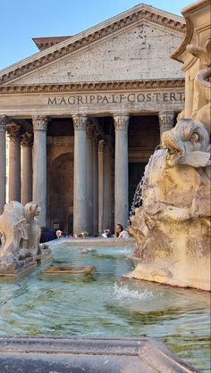 a fountain in front of a building with columns