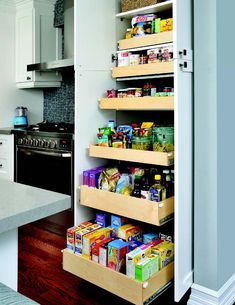 an open pantry door in a kitchen with lots of food on the shelves and drawers