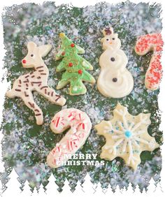 a group of decorated cookies sitting on top of a snow covered ground with words merry christmas