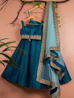 This is a three-piece Peacock Blue lehenga set with sky blue dupatta from the Anisha Shetty collection. This beautiful peacock blue rawsilk stone work lehenga is paired with a raw silk peacock blue embroidered blouse. The peacock blue color with stone work and embroidery enhances this lehenga set. The blouse has a sequin tassel tie-up at the back. The outfit is completed with a net sky blue dupatta with heavy gold embroidery border in peacock blue accent and badla work all over. Blue Art Silk Palazzo Set For Eid, Blue Raw Silk Anarkali Set For Diwali, Designer Blue Dola Silk Palazzo Set, Blue Chanderi Floor-length Palazzo Set, Blue Anarkali Raw Silk Palazzo Set, Blue Anarkali Style Raw Silk Palazzo Set, Blue Chanderi Sets For Reception, Festive Blue Palazzo Set With Zari Work, Blue Bollywood Art Silk Palazzo Set