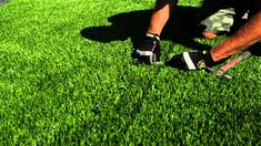 a man kneeling down on top of a lush green field