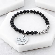 "This handmade latitude longitude bracelet features a gorgeous strand of geometric black agate beads, a custom engraved grid coordinates charm and stainless steel accent beads. A daily reminder of your special location, this personalised bracelet is the perfect gift for someone you love.  Made from high-quality stainless steel, the personalised latitude longitude charm is laser engraved in a dark charcoal grey colour.  Order this handmade latitude longitude bracelet today. You'll receive a beaut Cheap Personalized Black Charm Bracelet, Gift Stainless Steel Beaded Bracelets With Round Beads, Stainless Steel Beaded Bracelets With Round Beads As Gift, Stainless Steel Beaded Bracelets As Gift, Modern Beaded Bracelet With Black Beads As Gift, Personalized Minimalist Black Beaded Bracelets, Minimalist Personalized Black Beaded Bracelets, Personalized Black Minimalist Beaded Bracelets, Black Stainless Steel Jewelry With Round Beads