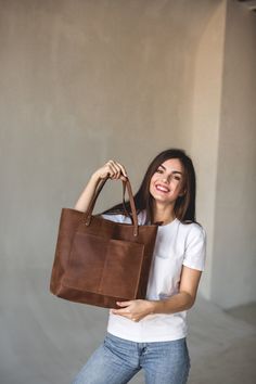 This handmade women tote bag is produced of cowhide leather. It has one pocket inside. The bag has a high-quality zipper that secures your belongings. It holds the shape perfectly and you may be confident that your personal things like cell phone, tablet, lap-top are safe. This bag is simple, reliable, and durable. Its universal look allows to use the tote bag for various purposes. One may take the bag to the work, shopping, meeting, or walk and feel comfortable with it at any conditions. SIZE: Tote Shoulder Bag With Silt Pocket For On-the-go, On-the-go Tote Bag With Silt Pocket, Tote Weekender Bag With Pockets, Leather Bag With Silt Pocket For Everyday Use, Leather Satchel With Pockets For Shopping, Leather Shoulder Bag With Pockets For Errands, Brown Tote Weekender Bag With Pockets, Leather Tote Bag With Pockets, Tote Bags With Zipper