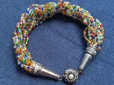 the beaded bracelet has a silver metal hook on it's end and is decorated with multicolored beads