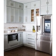 a kitchen with white cabinets and stainless steel appliances