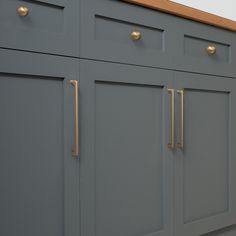 a kitchen with gray cabinets and gold handles