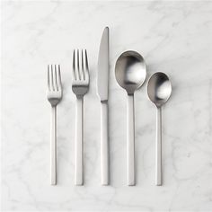 four forks, two spoons and one knife on a marble surface