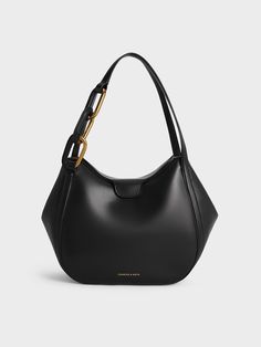 With the roomy interior of a classic tote, this black Kora bag is essentially two bags in one. Featuring a fold-over closure, which is secured with a magnetic clasp, this chic carrier comes with side flaps that can be tucked in or let out, so you can change it silhouette, as well as its carrying capacity, in an instant. In other words, this piece can be transformed to suit your needs and preferences. A bold and eye-catching chain-link detail on the handle makes it stand out even more. Charles And Keith Bags, Charles And Keith, Charles Keith, Black Bag, Magnetic Clasp, Black Tote Bag, Metallic Accents, Kids Gifts, Sales Gifts