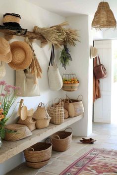 baskets and hats are hanging on the wall in this entryway, which is decorated with wicker