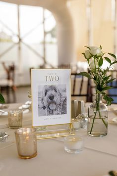 there is a vase with flowers in it and two pictures on the table next to each other