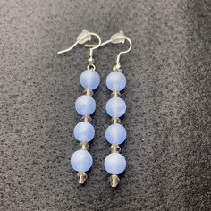 two pairs of blue glass beaded earrings sitting on top of a gray countertop