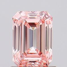 an unhealthy pink diamond is displayed on a white surface