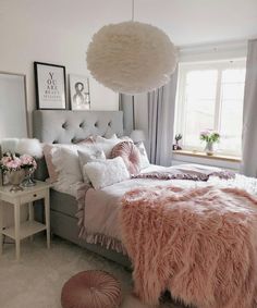 a white and pink bedroom with fluffy pillows