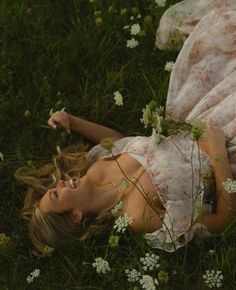 a woman laying in the grass with flowers