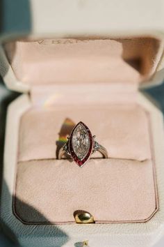 an engagement ring in a box with its lid open